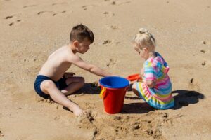 2 Kids enjoying summer activities on the beach